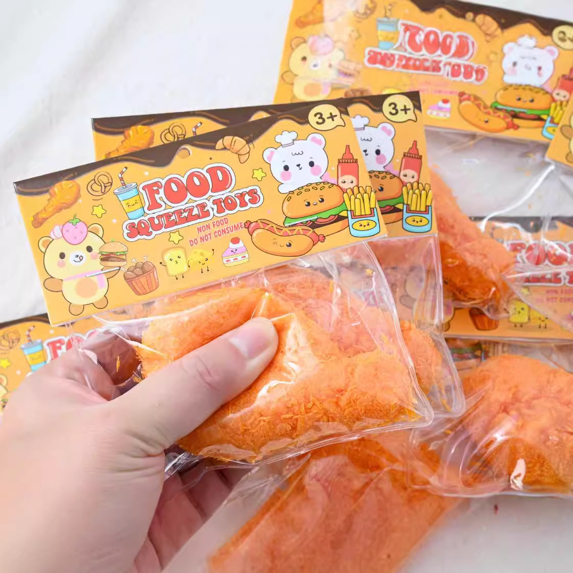 Cuốn sách đỏ và kem của Fry Fry để siết chặt chân gà của đồ chơi.