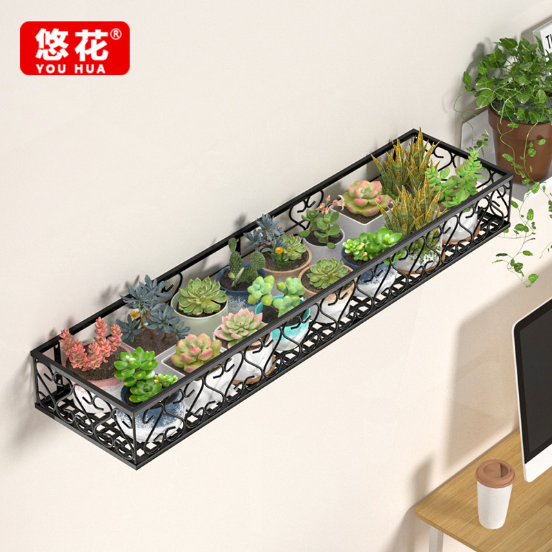 Giá đỡ cửa sổ bằng sắt với cửa sổ được cày và trồng cây xanh gắn vào kệ hoa