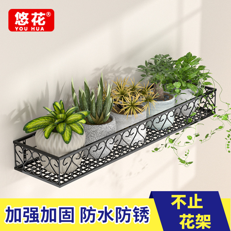 Giá đỡ cửa sổ bằng sắt với cửa sổ được cày và trồng cây xanh gắn vào kệ hoa