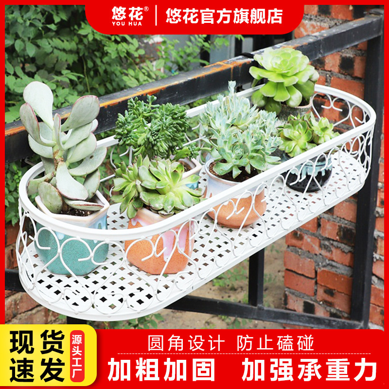 Một ô cửa sổ gắn tường với hàng rào thực vật