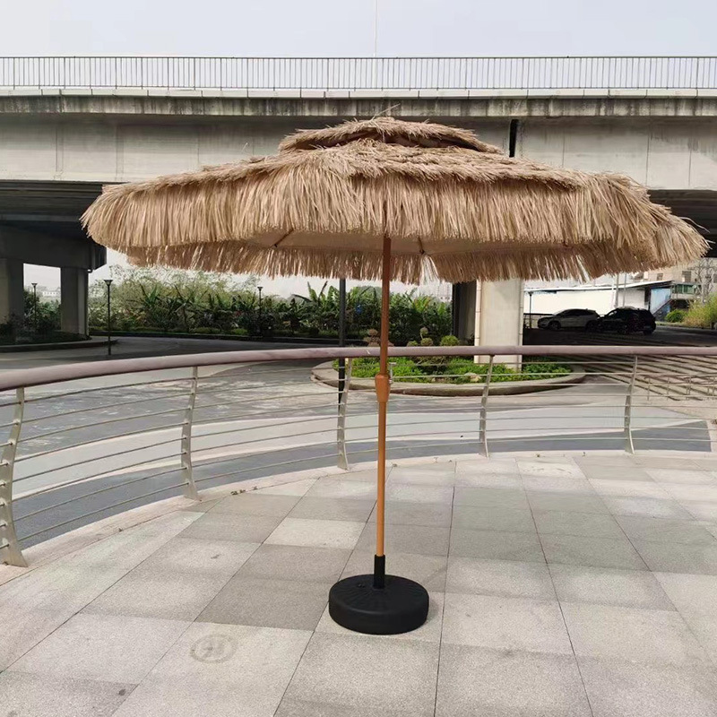 Two-top central umbrellas, round outdoors, with a large wind-shielded sun umbrella on the beachside of the courtyard.