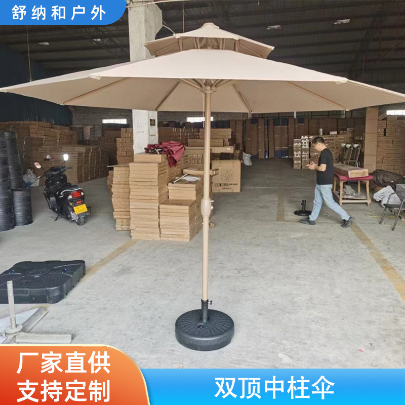 Two-top central umbrellas, round outdoors, with a large wind-shielded sun umbrella on the beachside of the courtyard.