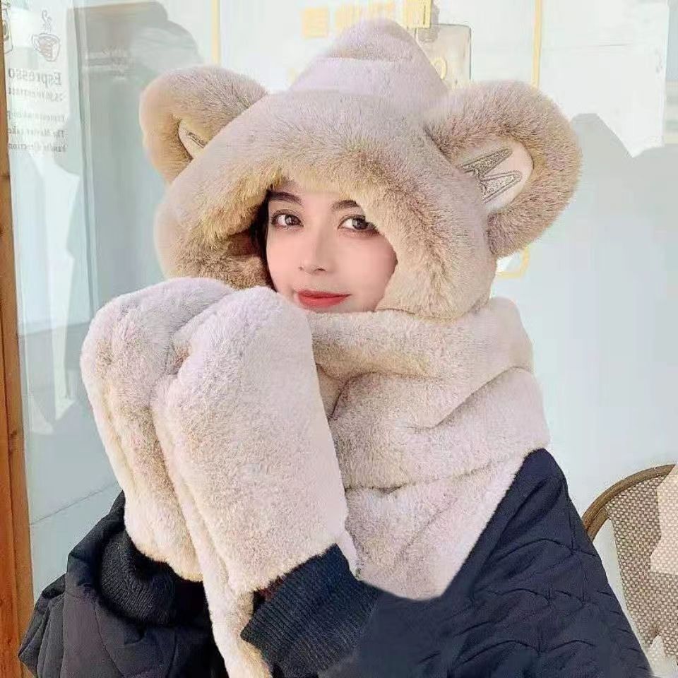 A bear hat girl with a hat scarf gloves in three pairs to keep her ears warm.