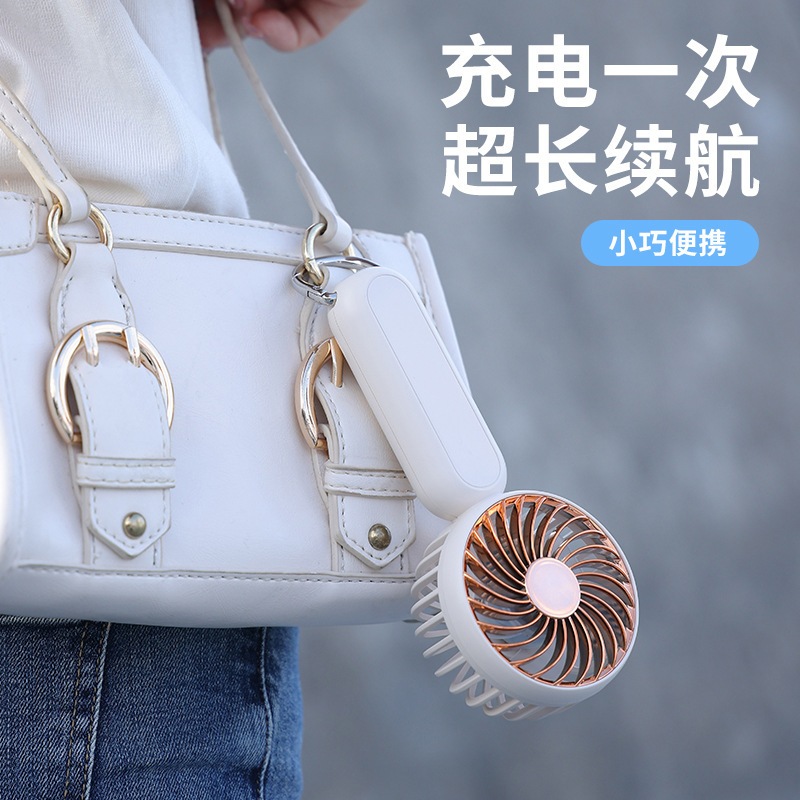 Một tay run rẩy với một fan hâm mộ và một nút leo núi đa mục đích để sạc một fan hâm mộ điện nhỏ để buôn bán.