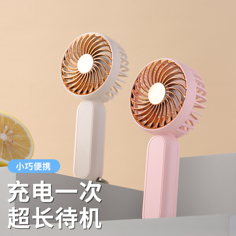 Một tay run rẩy với một fan hâm mộ và một nút leo núi đa mục đích để sạc một fan hâm mộ điện nhỏ để buôn bán.