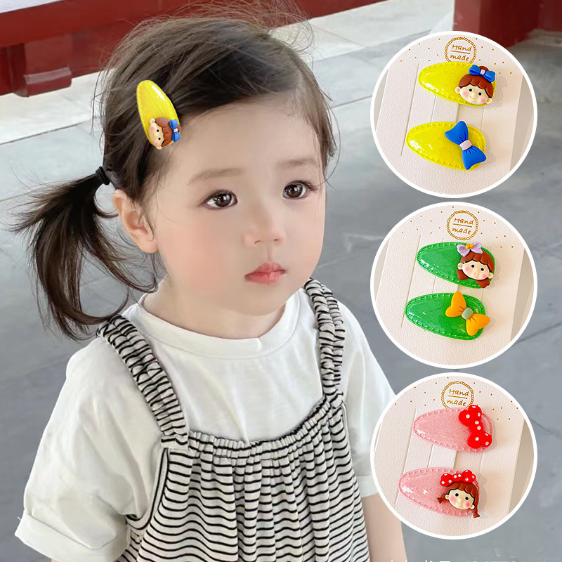 The baby's hair clips and cartoons, and the baby's cute and cute, and the baby's hair clips are broken on the side of the child's head in the summer.