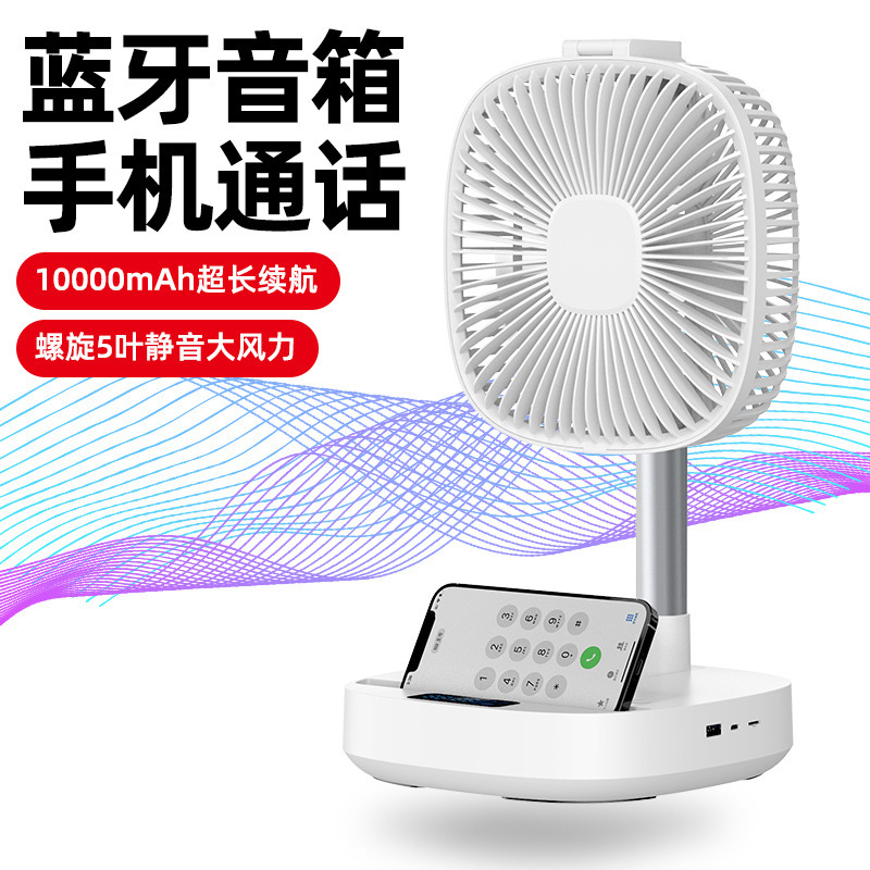 A small desktop fan of a portable office with a cell phone wirelessly charged music fan