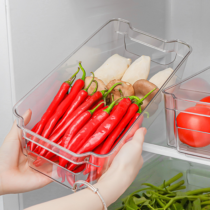 Một hộp thức ăn nhà bếp và rau cải trong tủ lạnh.