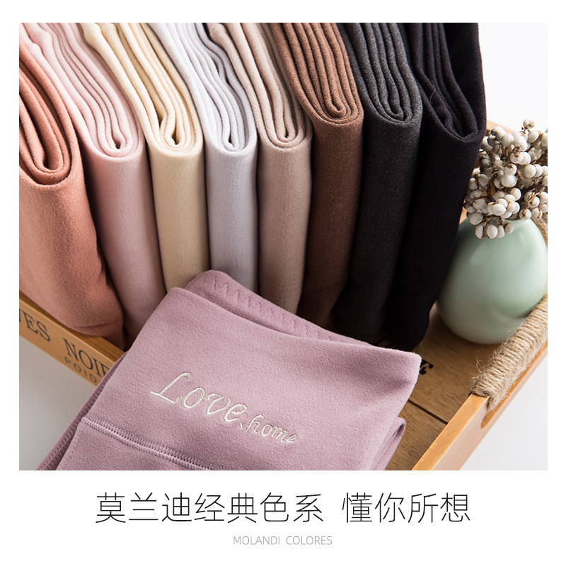 Người phụ nữ với những chiếc khăn len nhung với hai mặt của hai bông cỏ dại và vải bông ở phía sau và những bông cỏ dại không có một vết trầy xước.