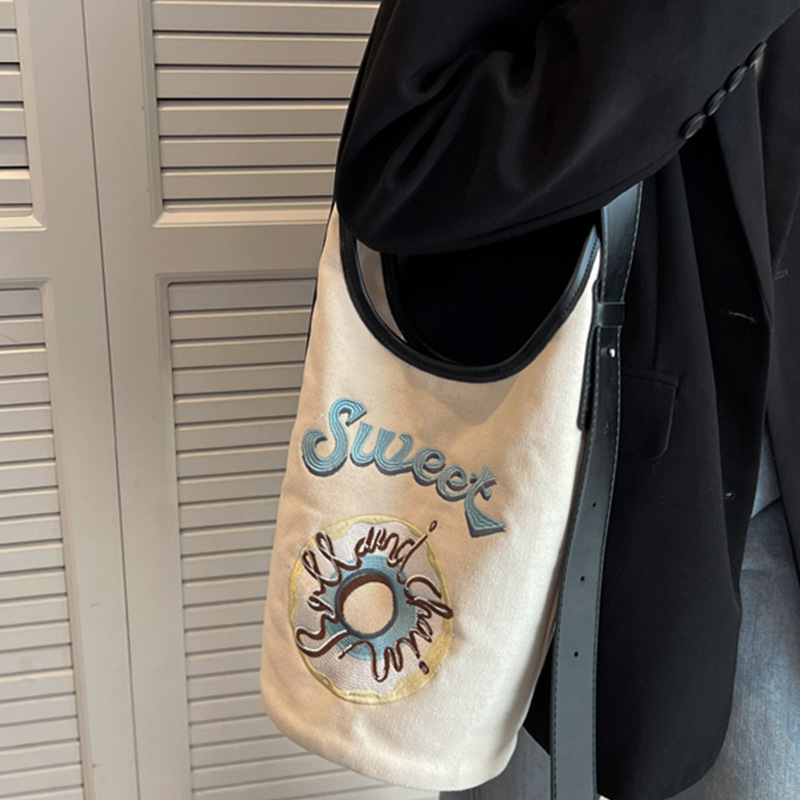 Japan and Koreas design one-shoulder donuts and one-shoulder buns with a bucket bag to embroider a girl bag.