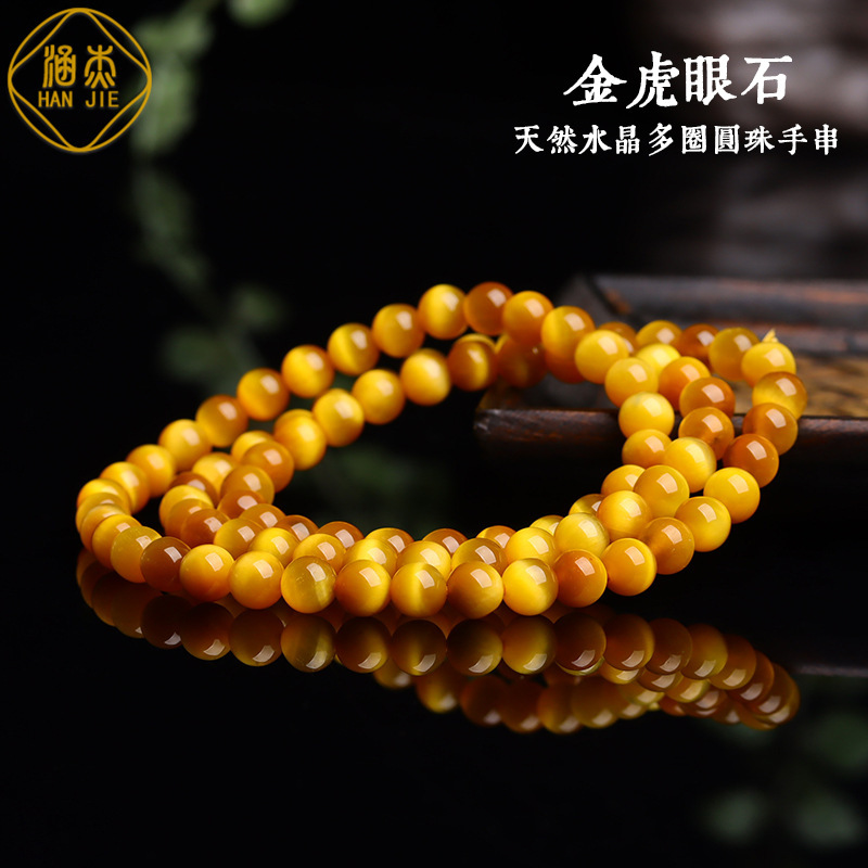 Wholesale of natural crystal tiger eyestones, rounded with golden-coloured cat-eyes.