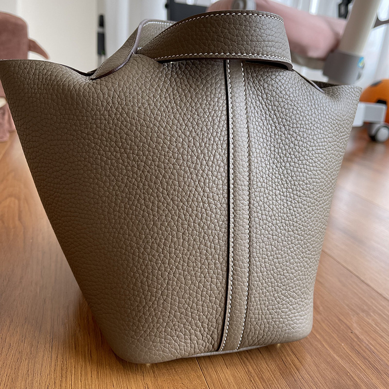 A bare-hand elephant, grey C22 basket with a leather bucket of twigs and twigs and twigs.