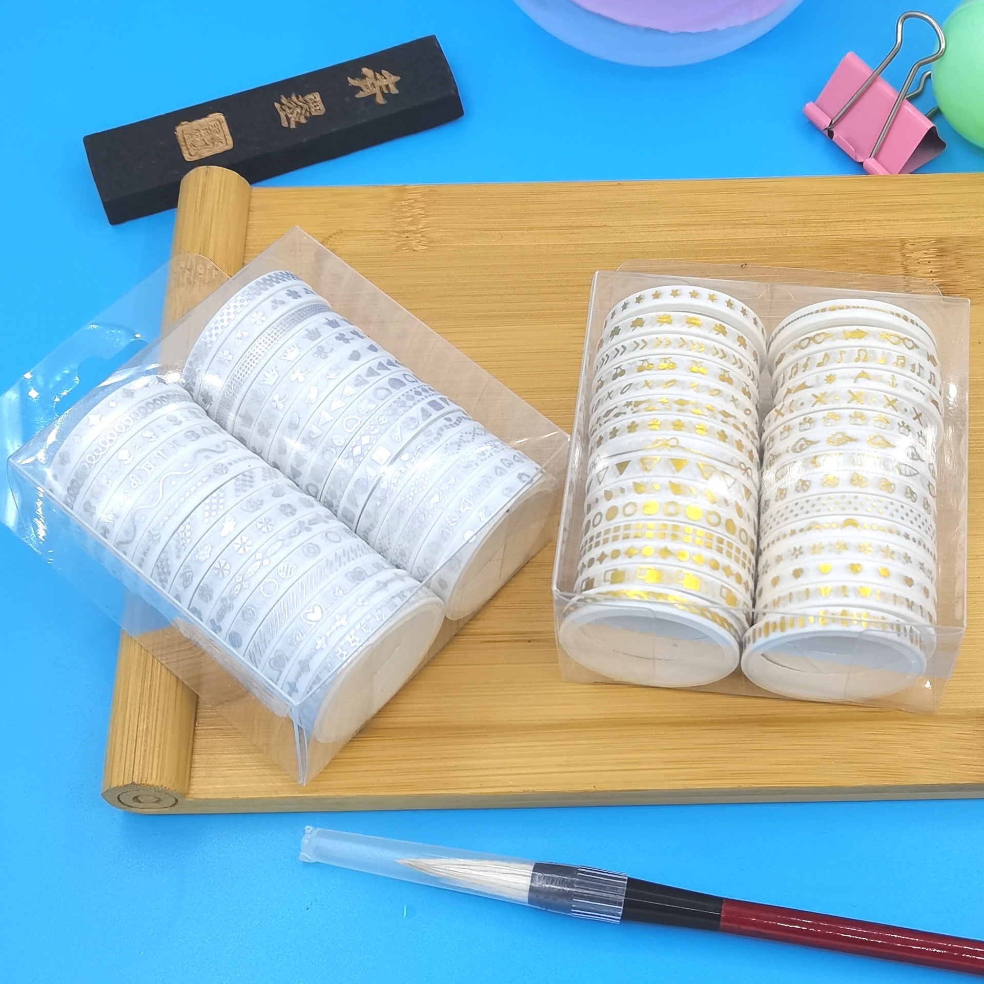 Vàng, bạc và hộp giấy với những cuốn sổ tay viền rất mỏng và những nhãn dán trang trí.