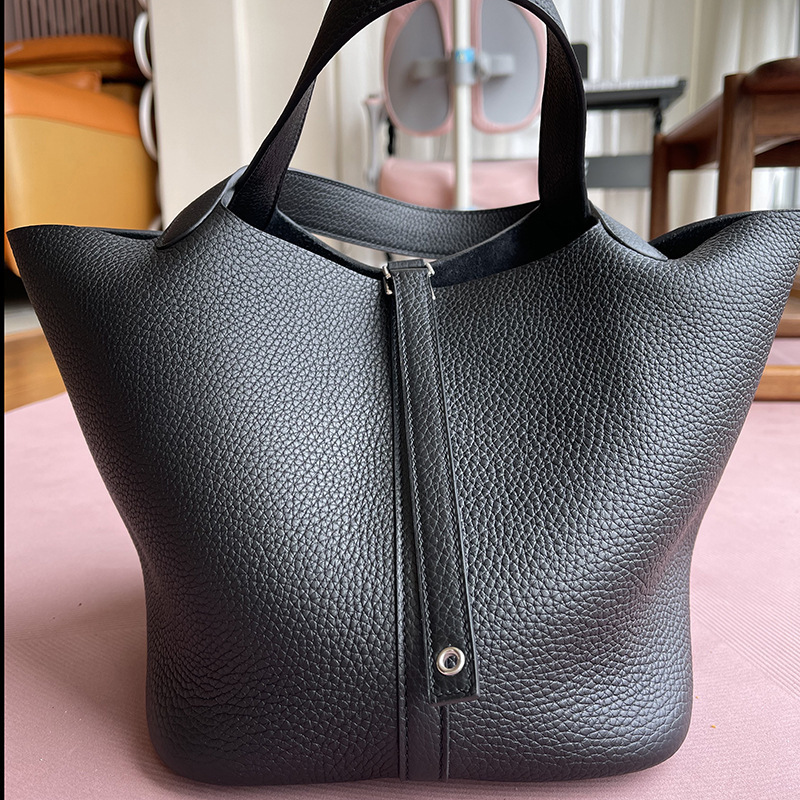 A bare-hand elephant, grey C22 basket with a leather bucket of twigs and twigs and twigs.