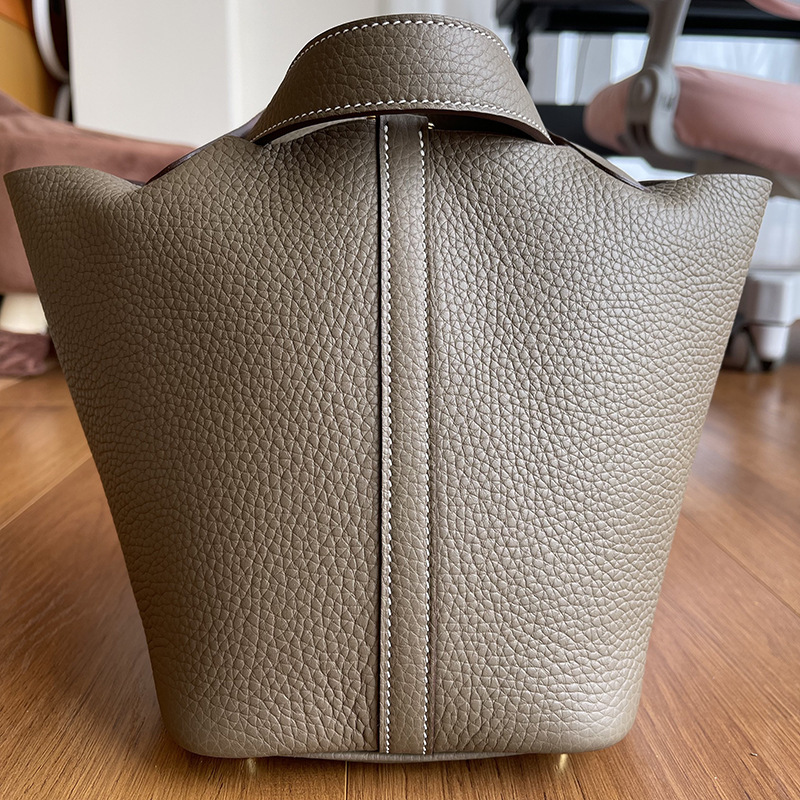 A bare-hand elephant, grey C22 basket with a leather bucket of twigs and twigs and twigs.
