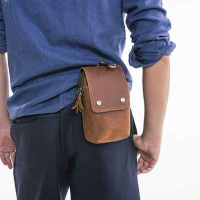 Head-covered cow-skinned man with an out-of-the-house exercise slant and an old crazy horse-skin bag with a multifunctional phone.