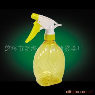 Một thùng nhỏ chứa chất khử trùng cồn do bình phun áp suất với một can nước nhỏ, trong suốt.