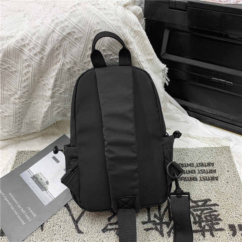 A new man with a single shoulder bag and a single chest bag with a full capacity to travel.