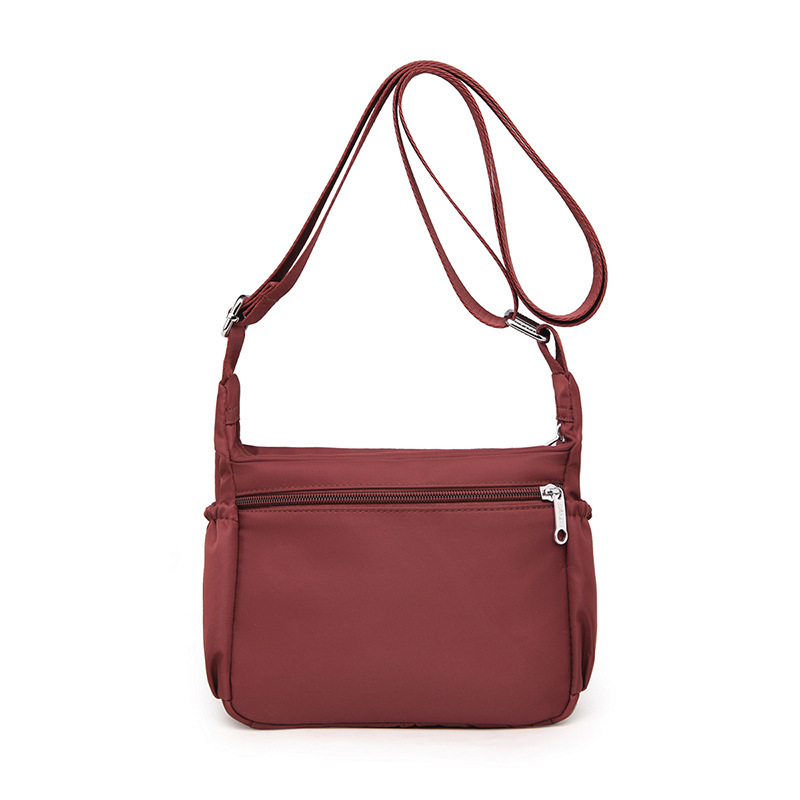 The one-shoulder-carrying, one-shoulder-free lady with a large waterproof nylon bag.