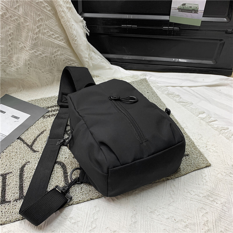 A new man with a single shoulder bag and a single chest bag with a full capacity to travel.