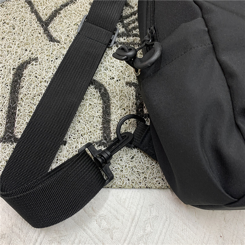 A new man with a single shoulder bag and a single chest bag with a full capacity to travel.