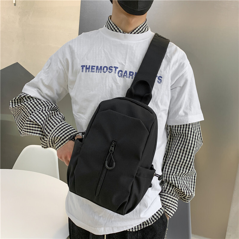 A new man with a single shoulder bag and a single chest bag with a full capacity to travel.