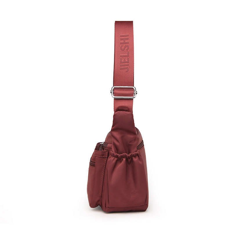 The one-shoulder-carrying, one-shoulder-free lady with a large waterproof nylon bag.