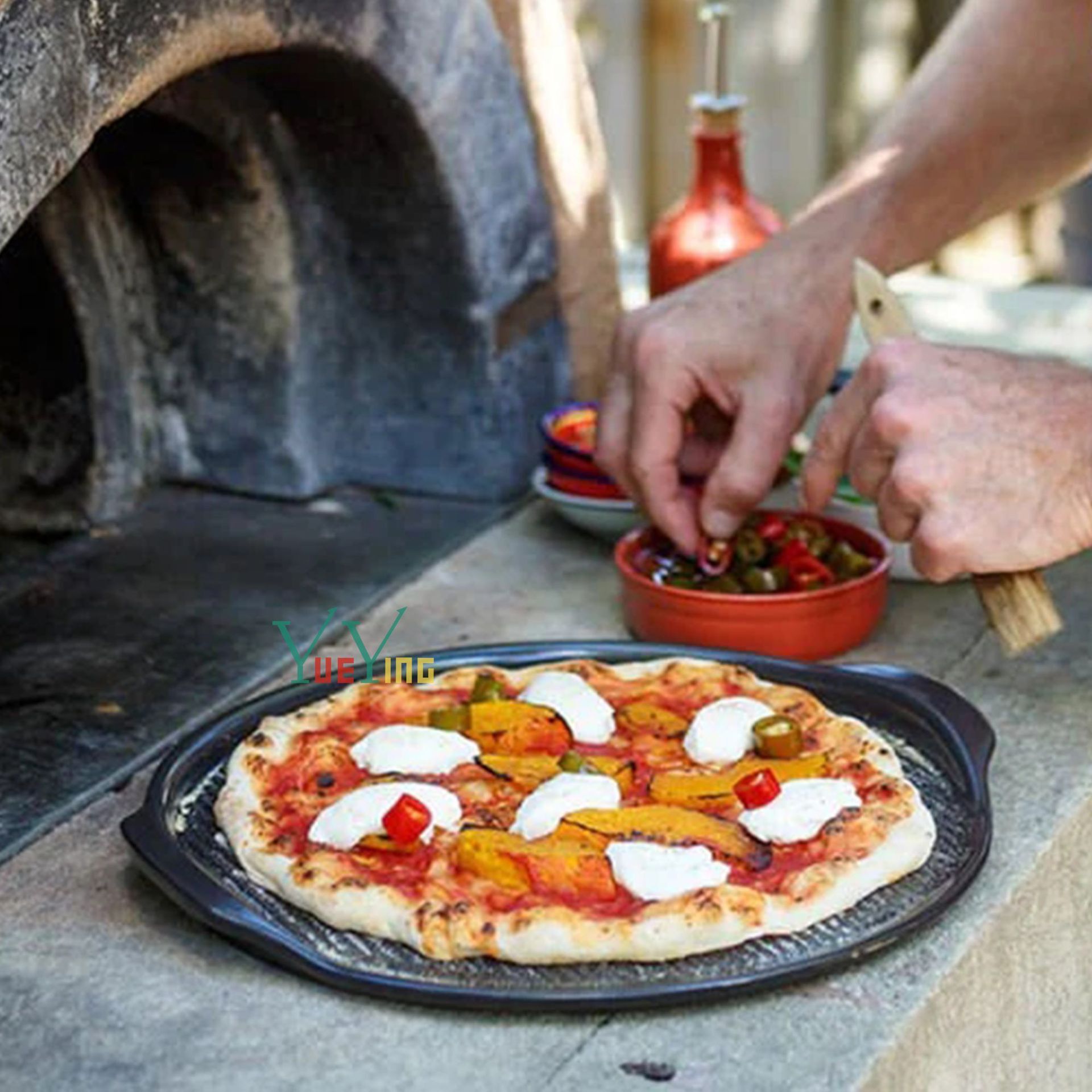 Pizza nướng với pizza cầm tay ở hai bên miếng nướng tròn.
