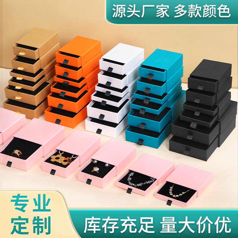 Một chiếc vòng cổ màu hồng trắng bọc với đinh đeo nhẫn đen trong một ngăn kéo chấm.