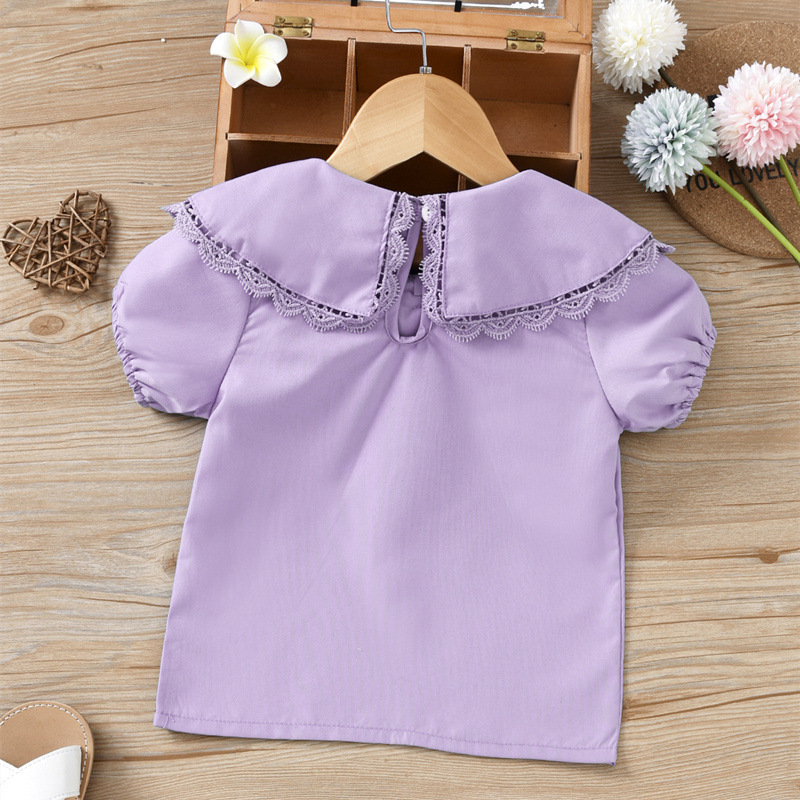 Con búp bê dễ thương của cô gái mặc một chiếc áo mùa hè, chiếc áo sơ mi màu sắc ngắn của cô bé, chiếc váy trẻ em thương mại.