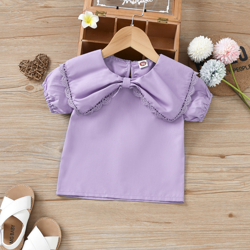Con búp bê dễ thương của cô gái mặc một chiếc áo mùa hè, chiếc áo sơ mi màu sắc ngắn của cô bé, chiếc váy trẻ em thương mại.