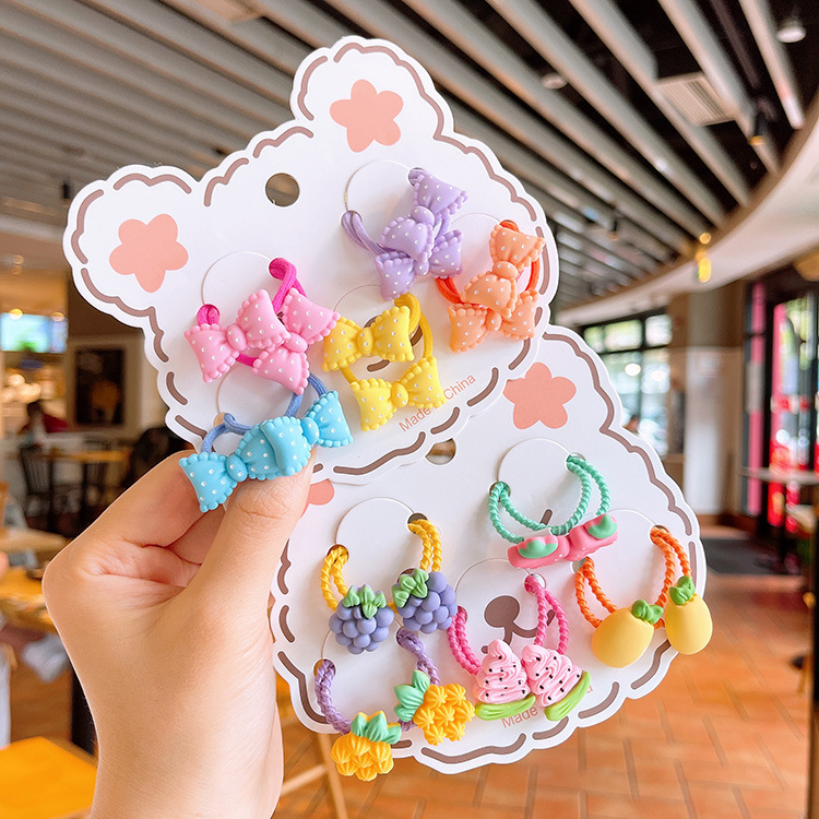 Ten little girls in summer hairs with a sutureless candy-colored cartoon fruit.