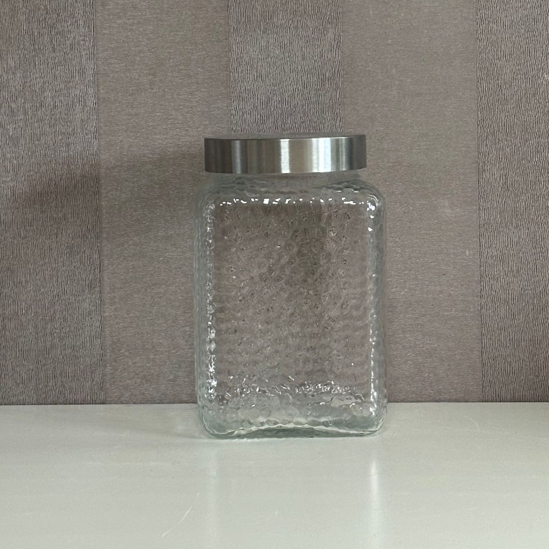 A glass bottle and a glass-seated glass storage tank and a dried fruit can and juice can.