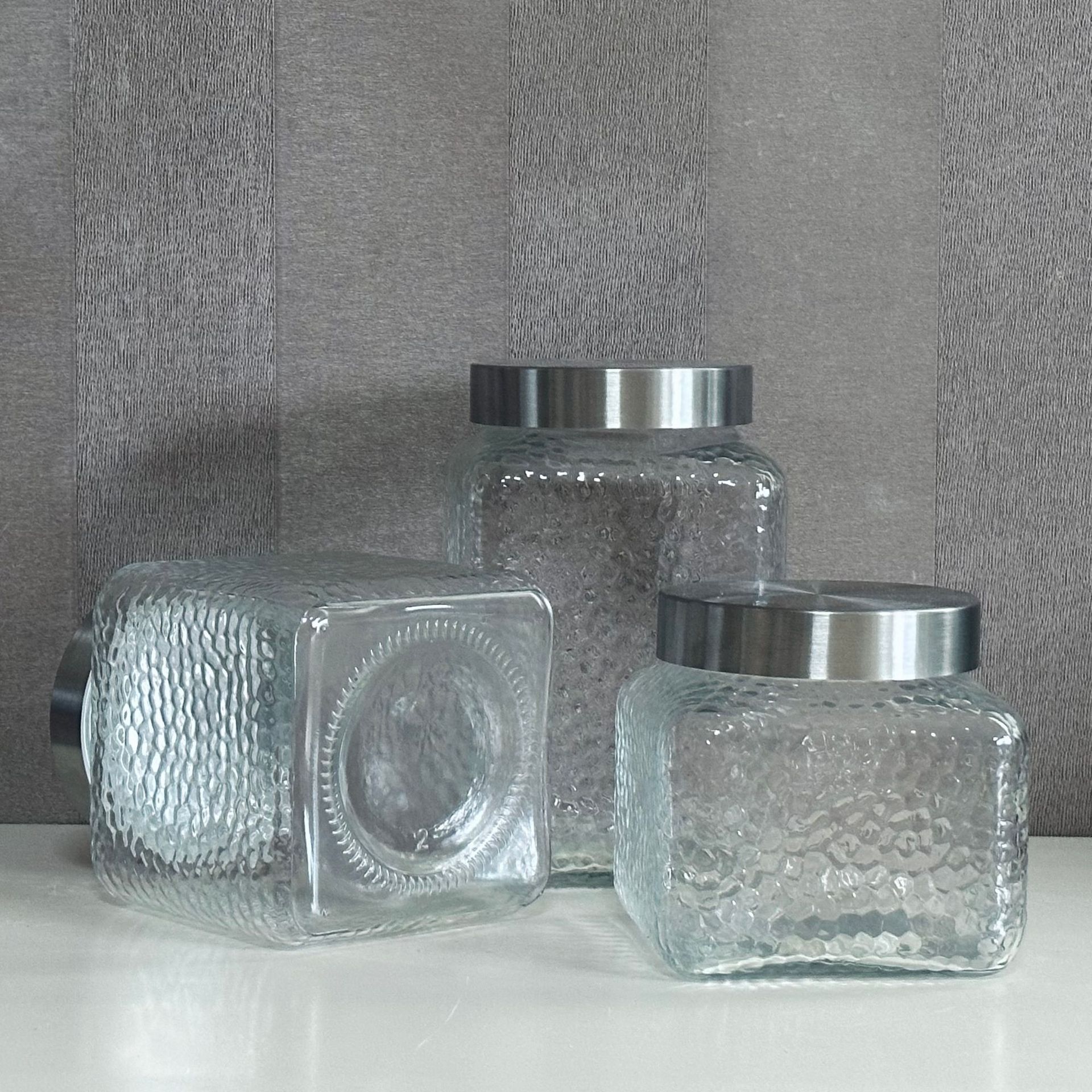 A glass bottle and a glass-seated glass storage tank and a dried fruit can and juice can.