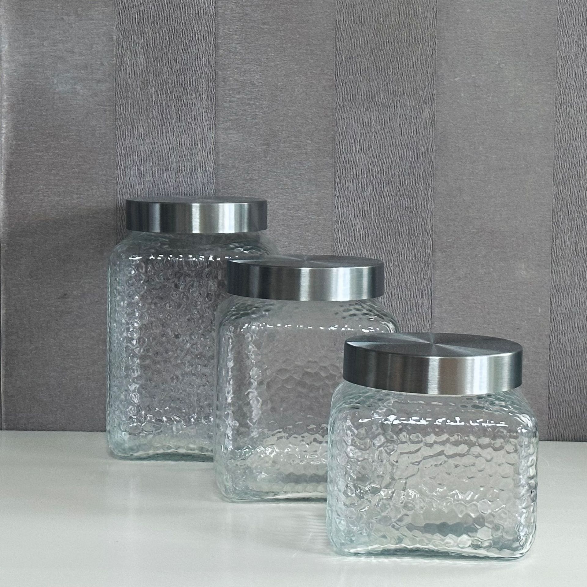 A glass bottle and a glass-seated glass storage tank and a dried fruit can and juice can.