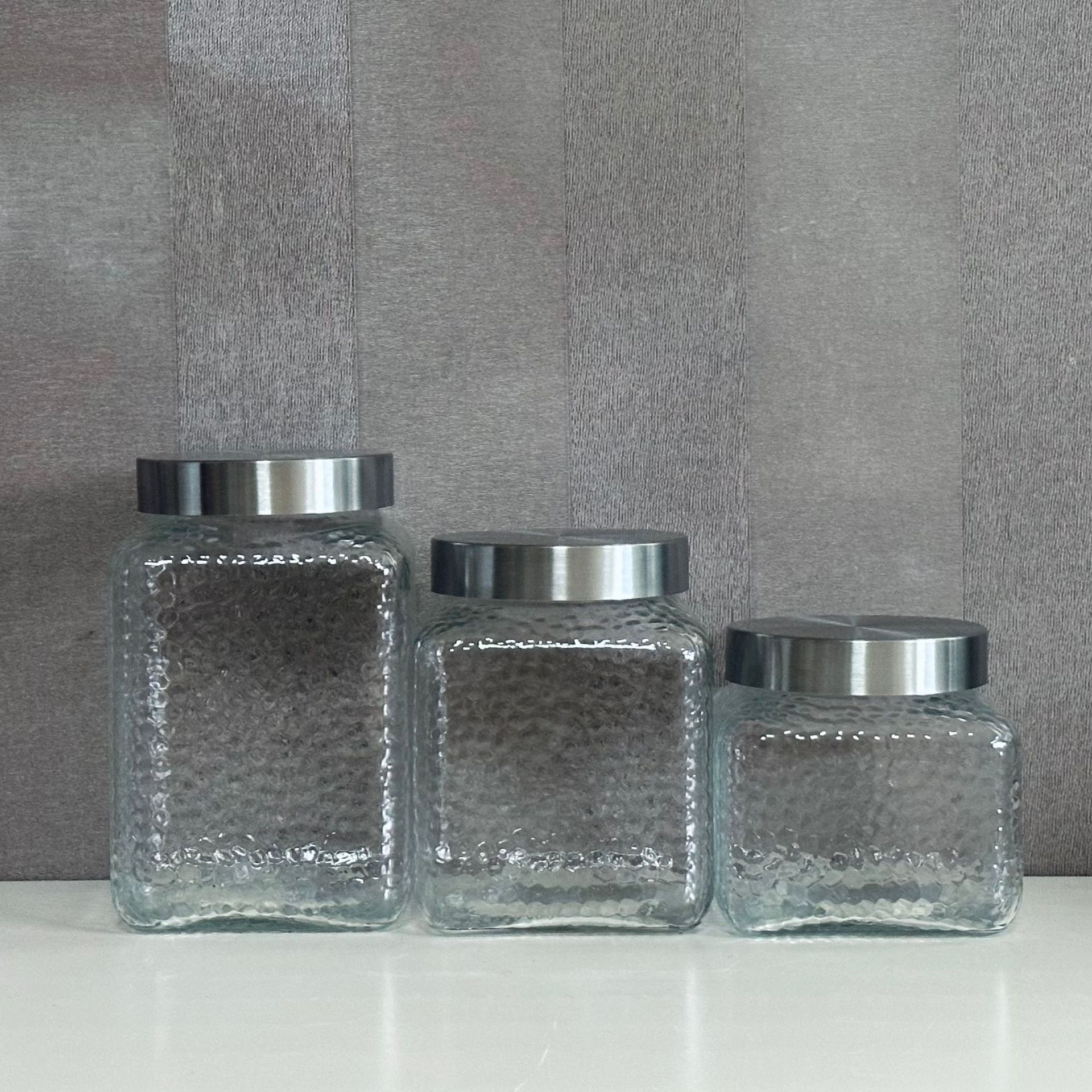 A glass bottle and a glass-seated glass storage tank and a dried fruit can and juice can.