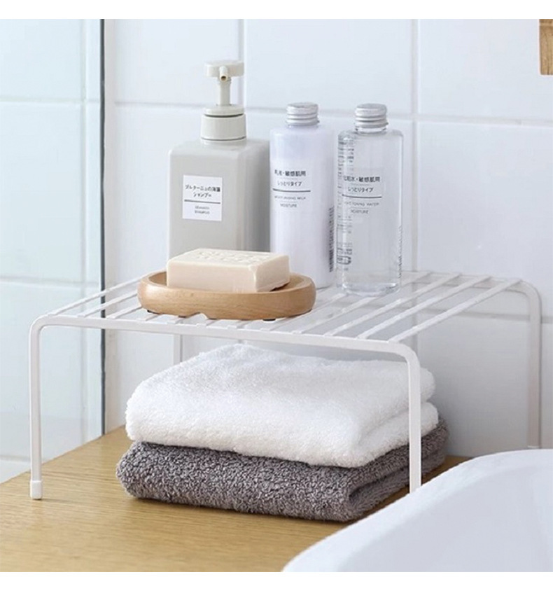 Nhà bếp trải dài hai kệ sắt và kệ sách chứa một cái chảo trong ngăn tủ.