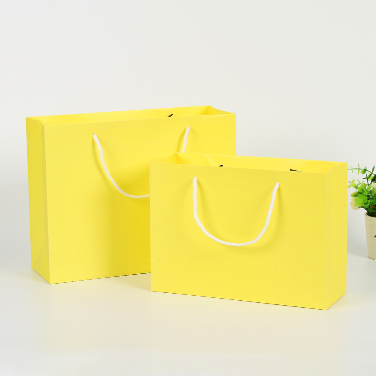 Clothes white card paper bags are customised for hand-held clothing shopping bags and folded bags are printed