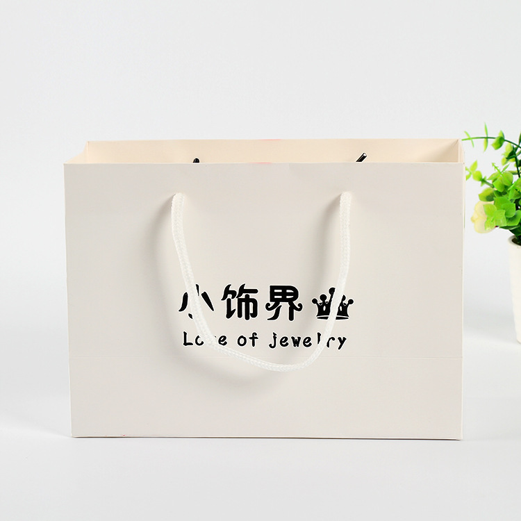 Hand-in-hand white card paper bag at the fashion shop to customize the shopping bag for creative gift bags