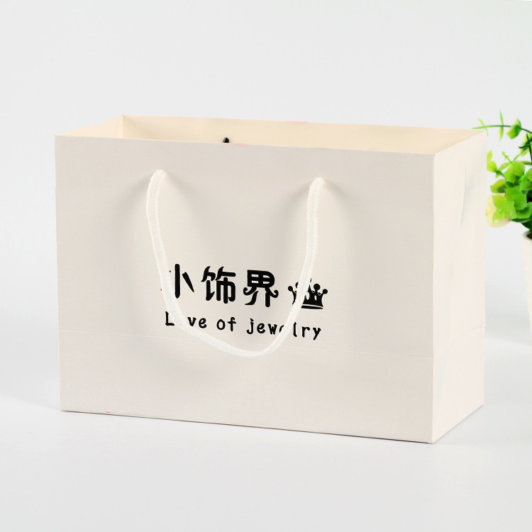 Hand-in-hand white card paper bag at the fashion shop to customize the shopping bag for creative gift bags