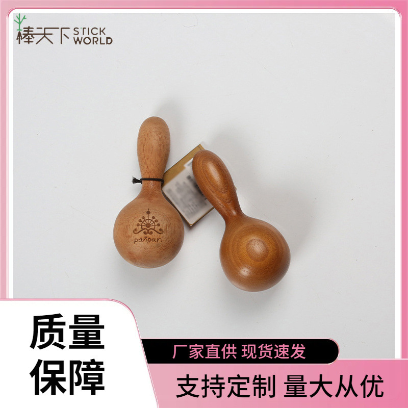 A Thai wood massager with a spa massage stick on the face.