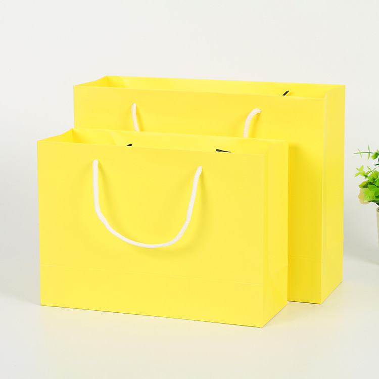 Clothes white card paper bags are customised for hand-held clothing shopping bags and folded bags are printed