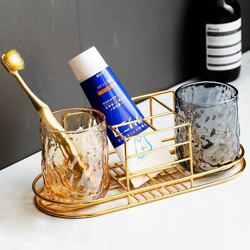 A wall-mounted stand with a toothbrush and a toothbrush and a toothbrush set in the bathroom