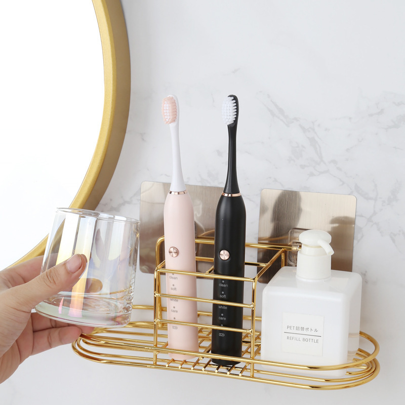 A wall-mounted stand with a toothbrush and a toothbrush and a toothbrush set in the bathroom