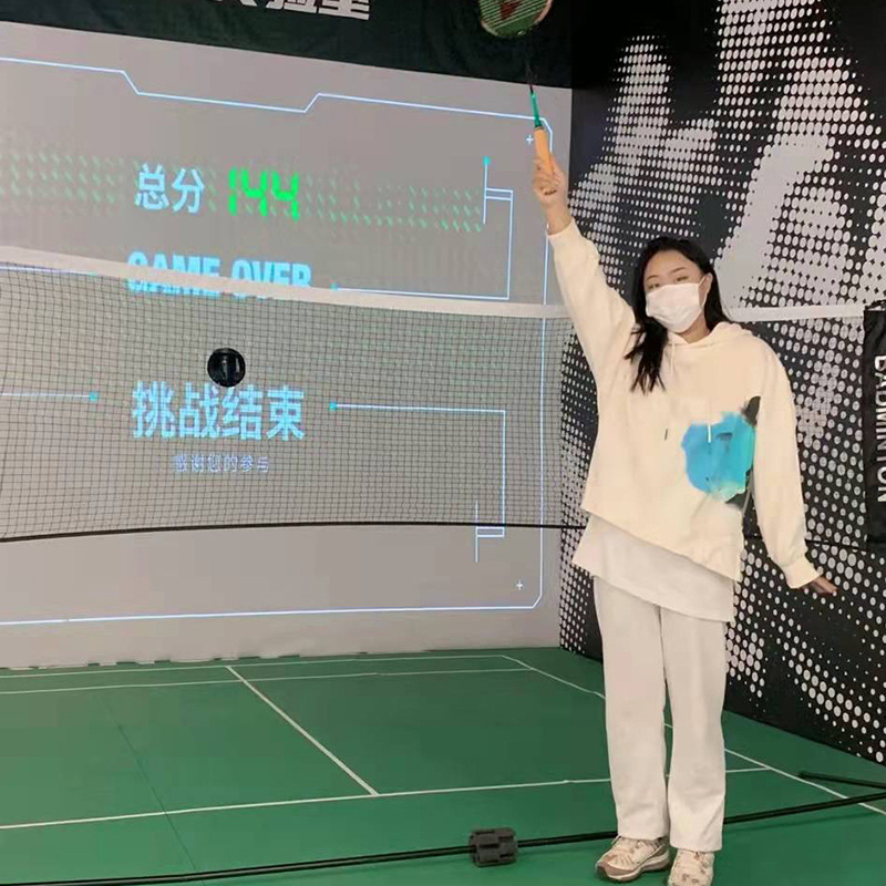 The indoor badminton experience hall automatically launches digital sports simulator gaming equipment for large games.