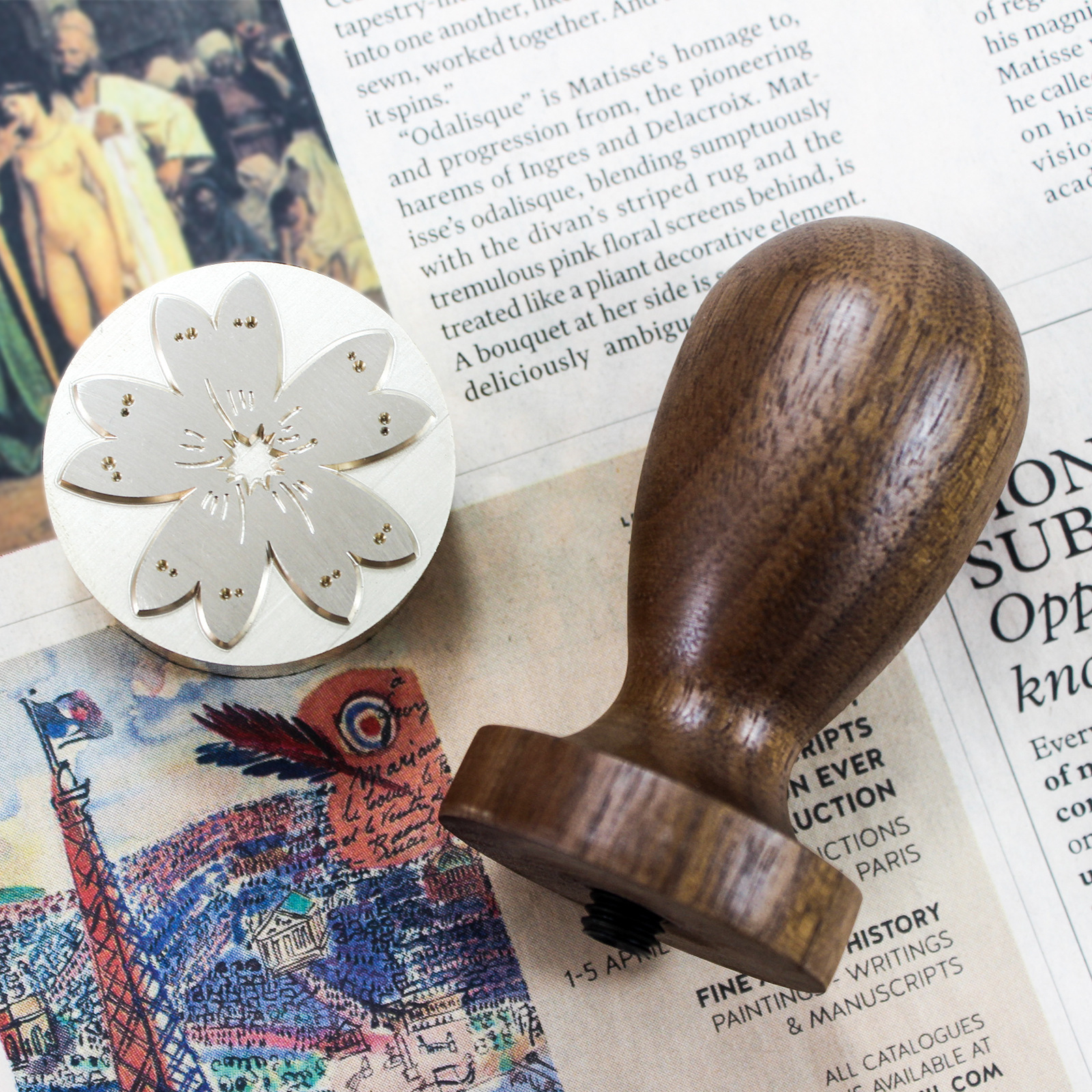 Black walnut wood handler with multi-letter copper-headed ice stamped on a glass of ice.