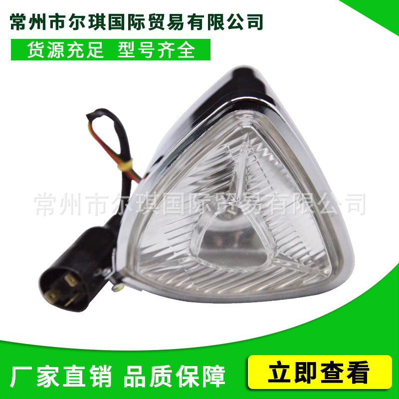 Old schoolhari motorcycle retrofitted triangular metal-glass frontlights approaching light fittings