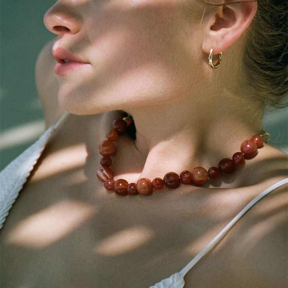 A simple choker chain of red beads, a simple choker chain of winter.