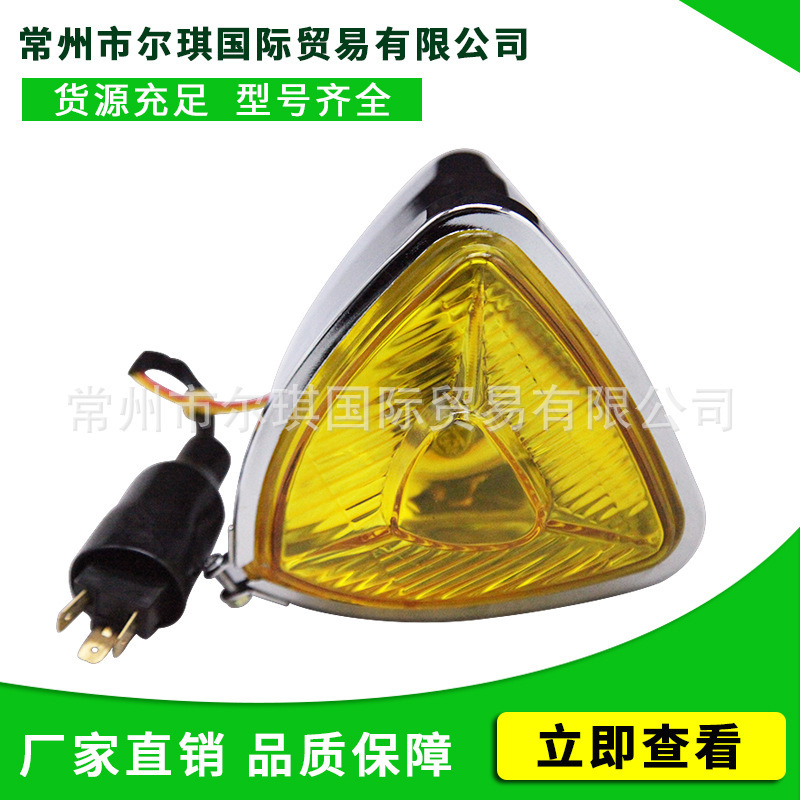 Old schoolhari motorcycle retrofitted triangular metal-glass frontlights approaching light fittings