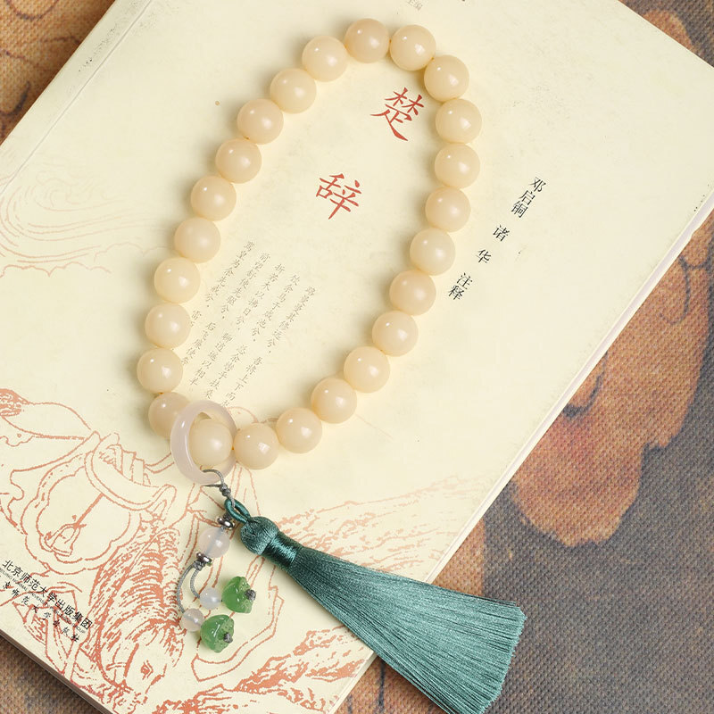 Bottigan bàn tay của Botigan trong cái vòng tay cao cấp tự nhiên của Phật tử Tita, đang chơi với chiếc vòng của Đức Phật.